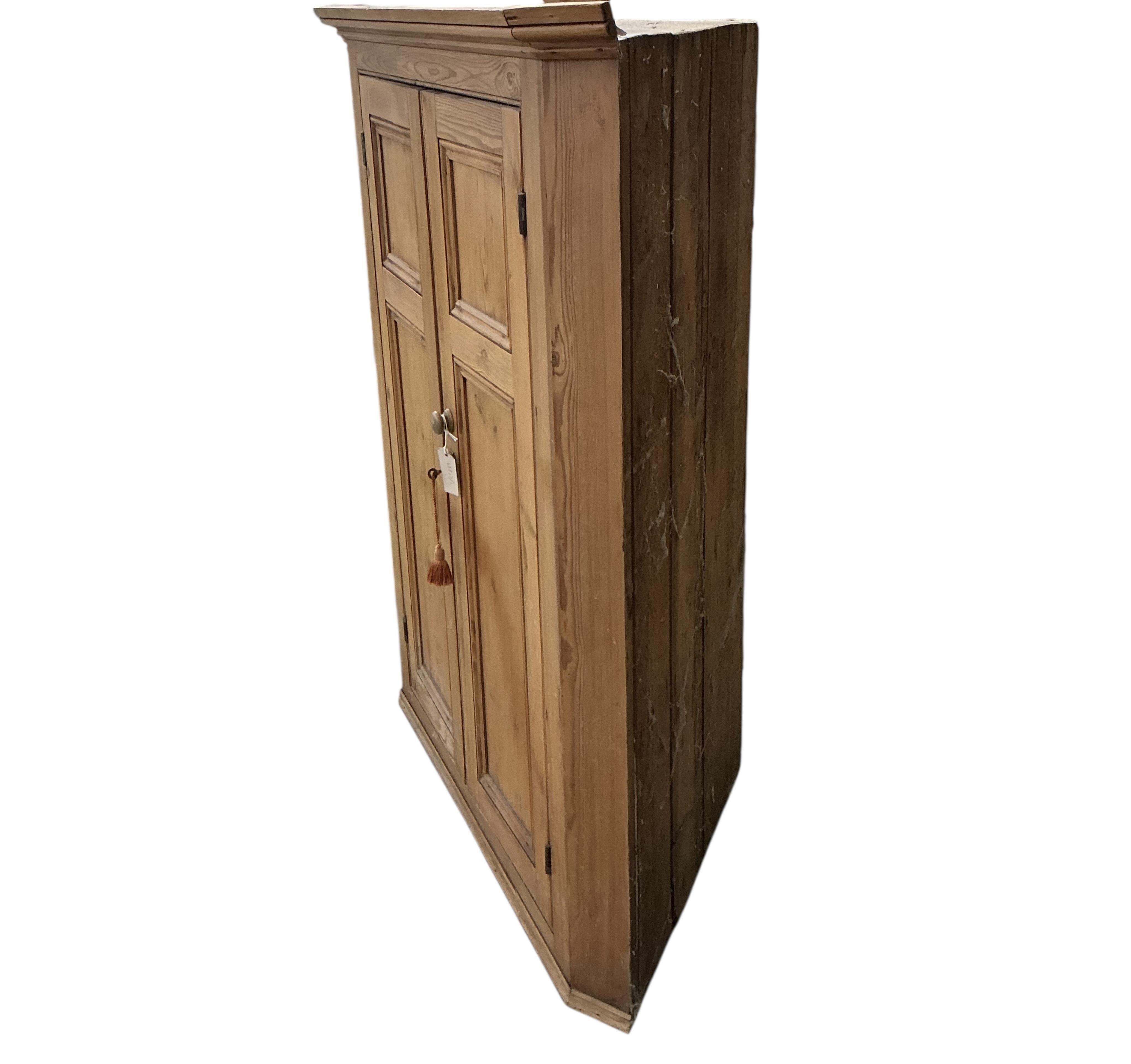 A Victorian panelled pine hanging corner cabinet, width 102cm, depth 53cm, height 126cm